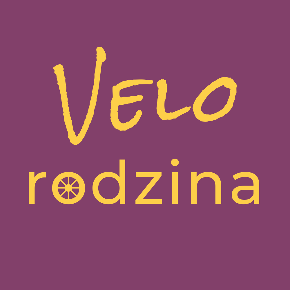 logo Velo Rodzina – żółty napis z nazwą na fioletowym tle gdzie litera O w wyrazie rodzina jest w kształcie koła roweru z widocznymi szprychami